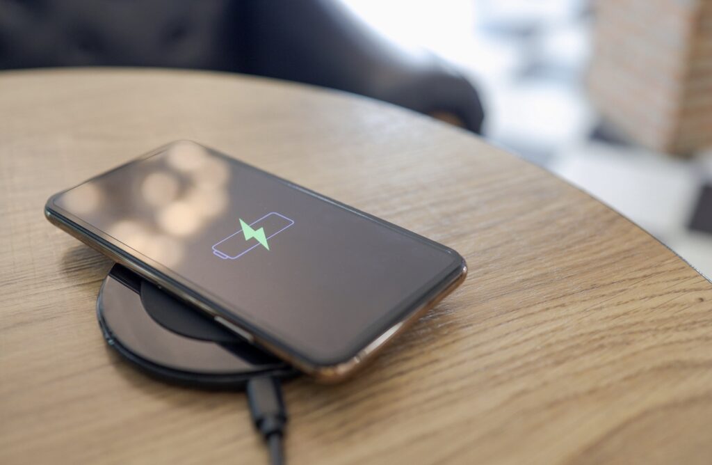 Apple iPhone charging on wooden table