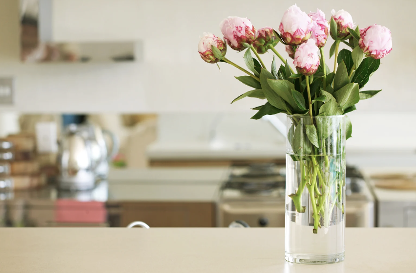 Pink flowers sitting in vase on counter top