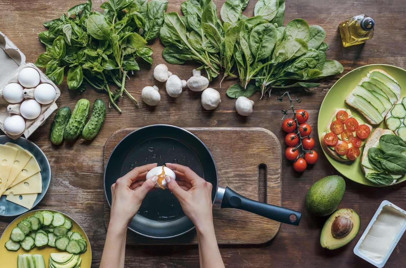 Woman cracking egg and eating healthy with vegetables and fruit