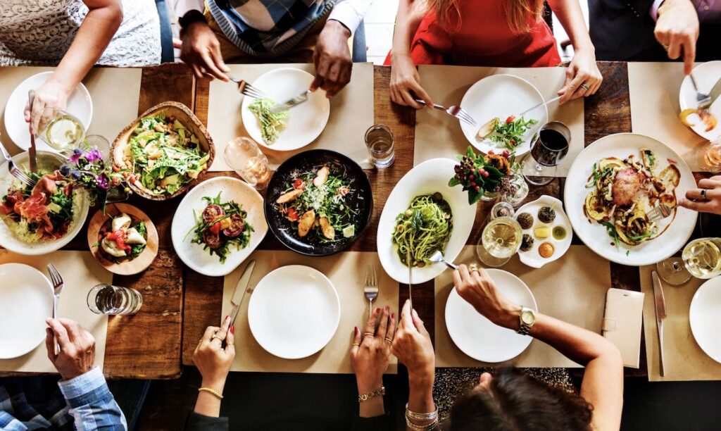 People gathered around table eating blood sugar supportive food