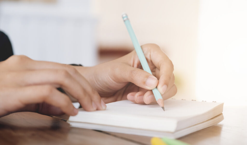 Woman writing in journal during a health coaching session