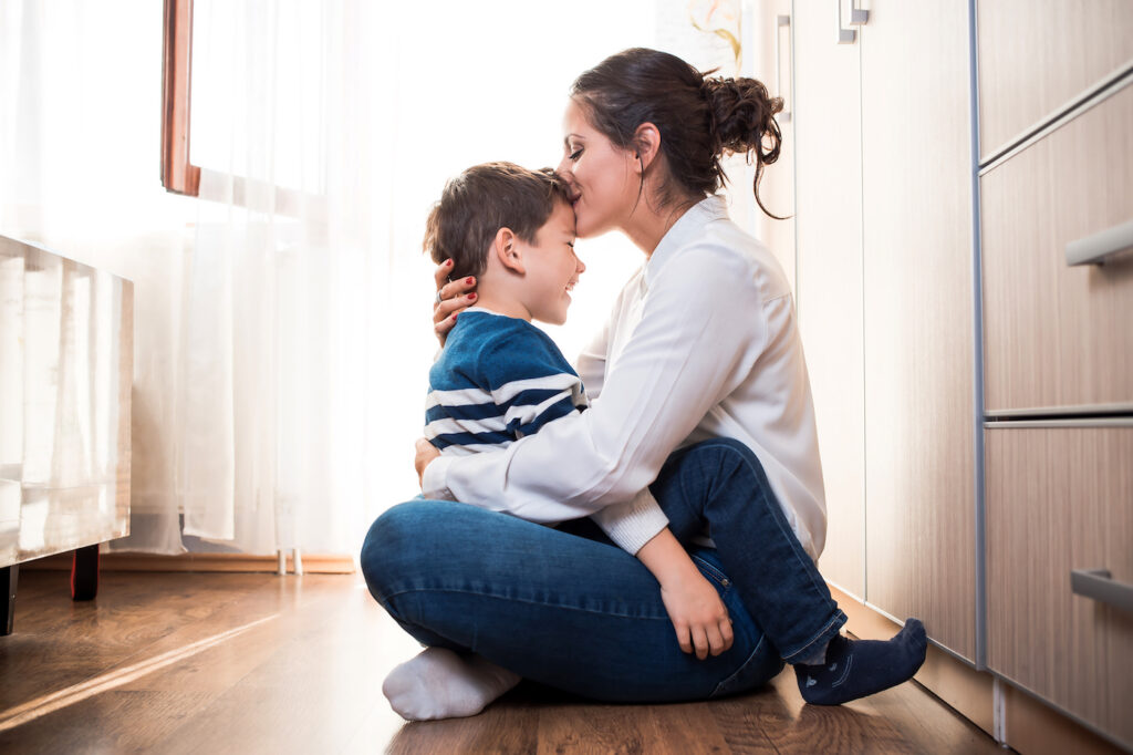 Young Type 1 Diabetes Mom Sitting and Kissing Young Son