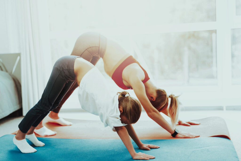 Young mom and daughter stretching for better T1D management