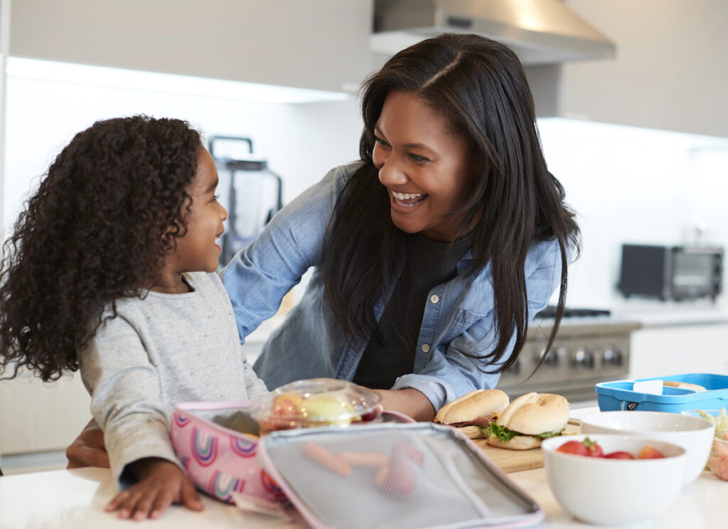 Type 1 diabetes mom helping young daughter pack blood sugar supportive school lunch