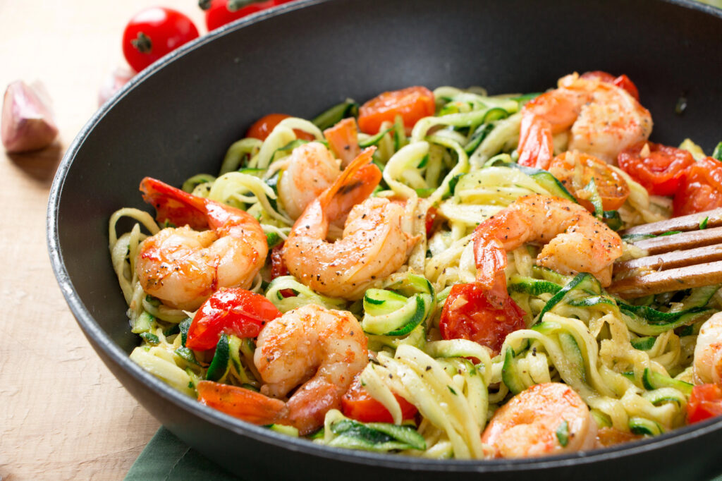 blood sugar supportive zucchini noodles with shrimp and tomatoes in black bowl